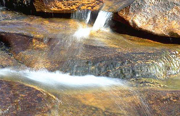 Photo: Close-up of water flowing over rocks