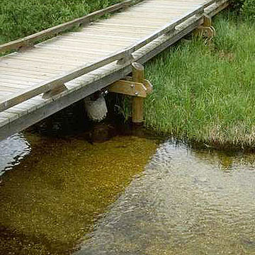Photo: Small footbridge with water flowing under it