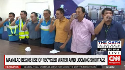 A stillshot of a video; officials tasting recycled water